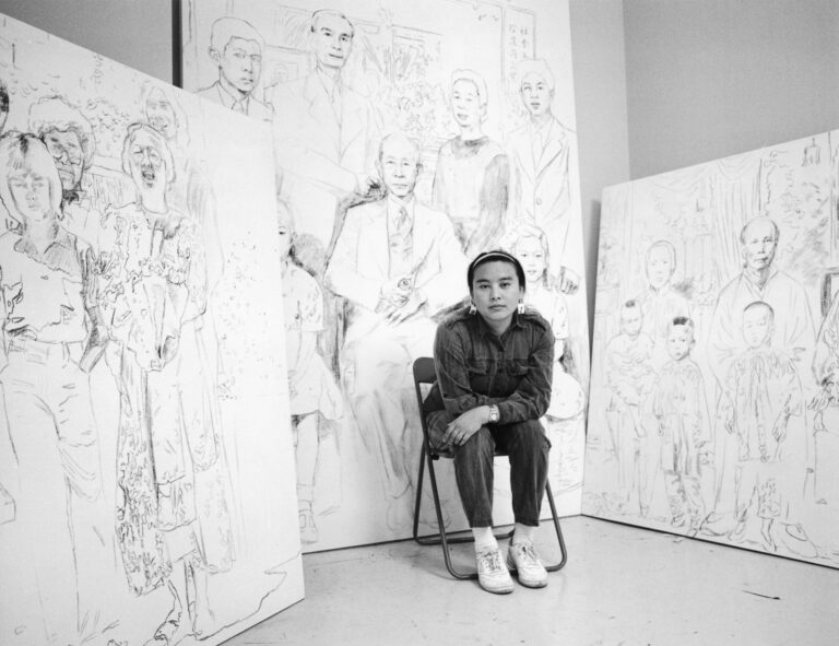 Black and white photograph of artist Hung Liu in from of her work